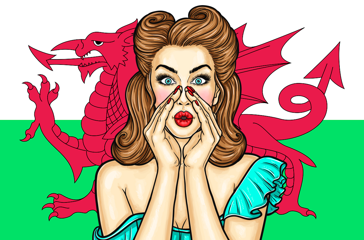 Woman in dress makes a circle with her palms around her mouth with Wales Flag background.